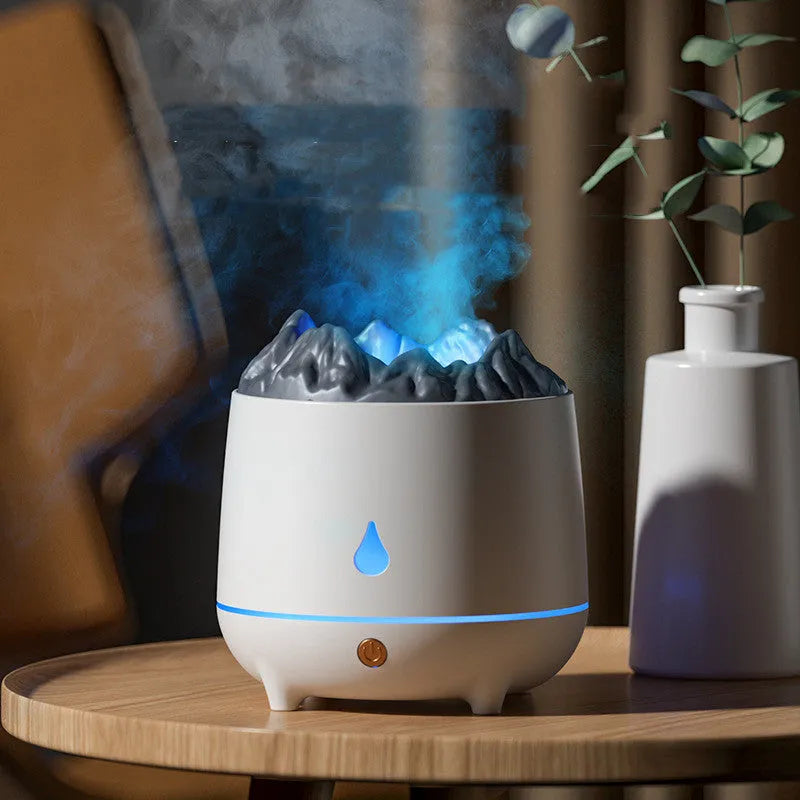 White volcano-shaped ultrasonic humidifier with USB cable on a wooden desk.