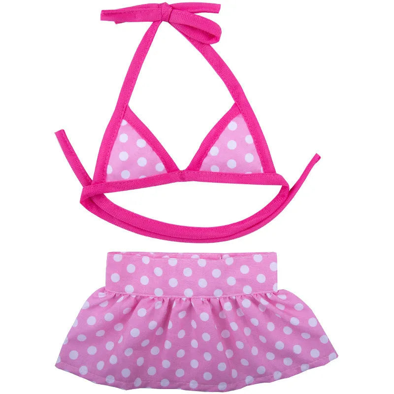 Dog wearing a pink dots polyester bikini suit lying on grass, summer pet clothing