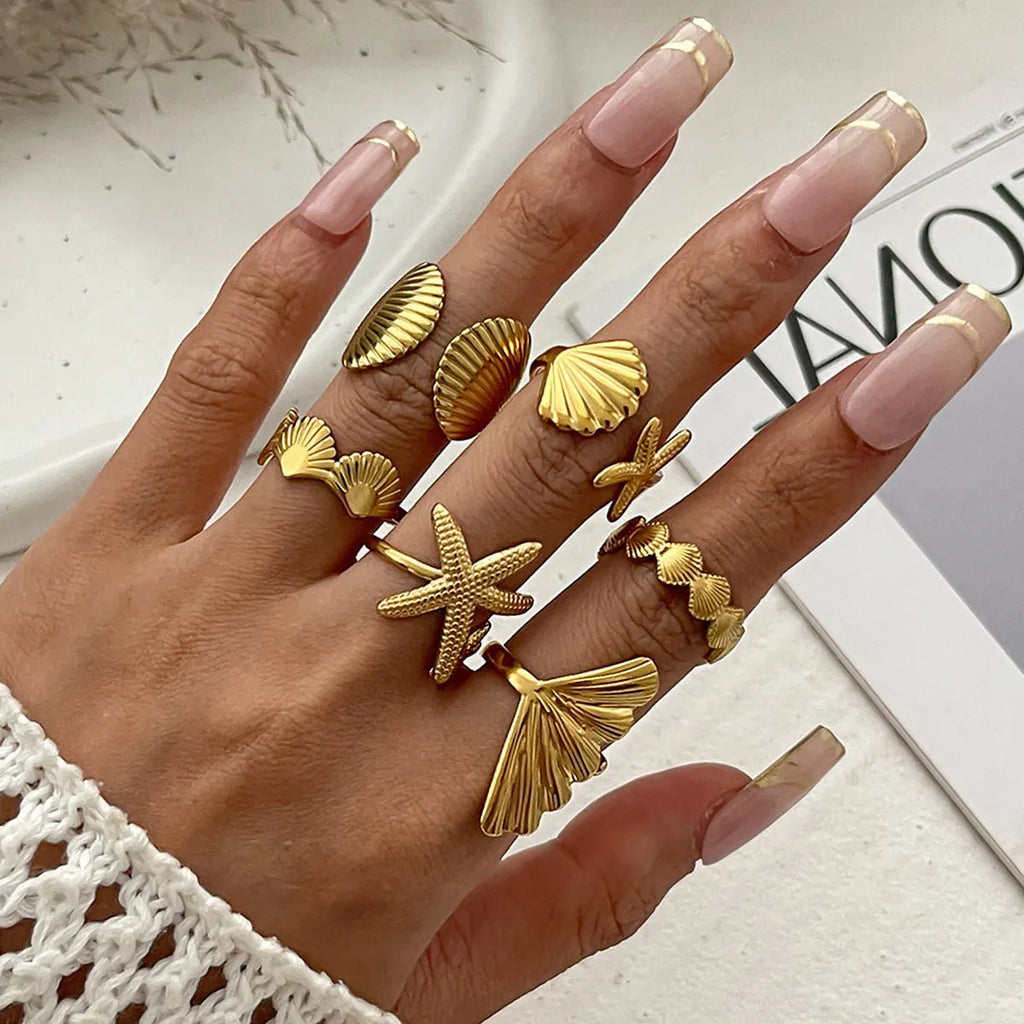 Women's irregular ocean shell ring set with starfish and fan shapes, light gold electroplated metal, 4-piece arrangement