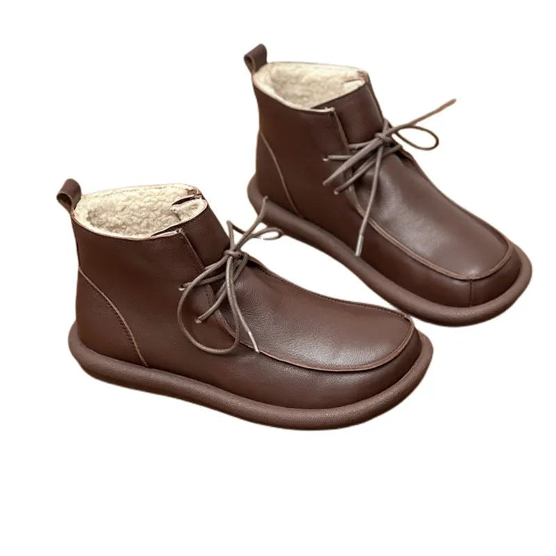 Women's black cowhide boots with a flat heel and round toe, featuring a velvet lining.