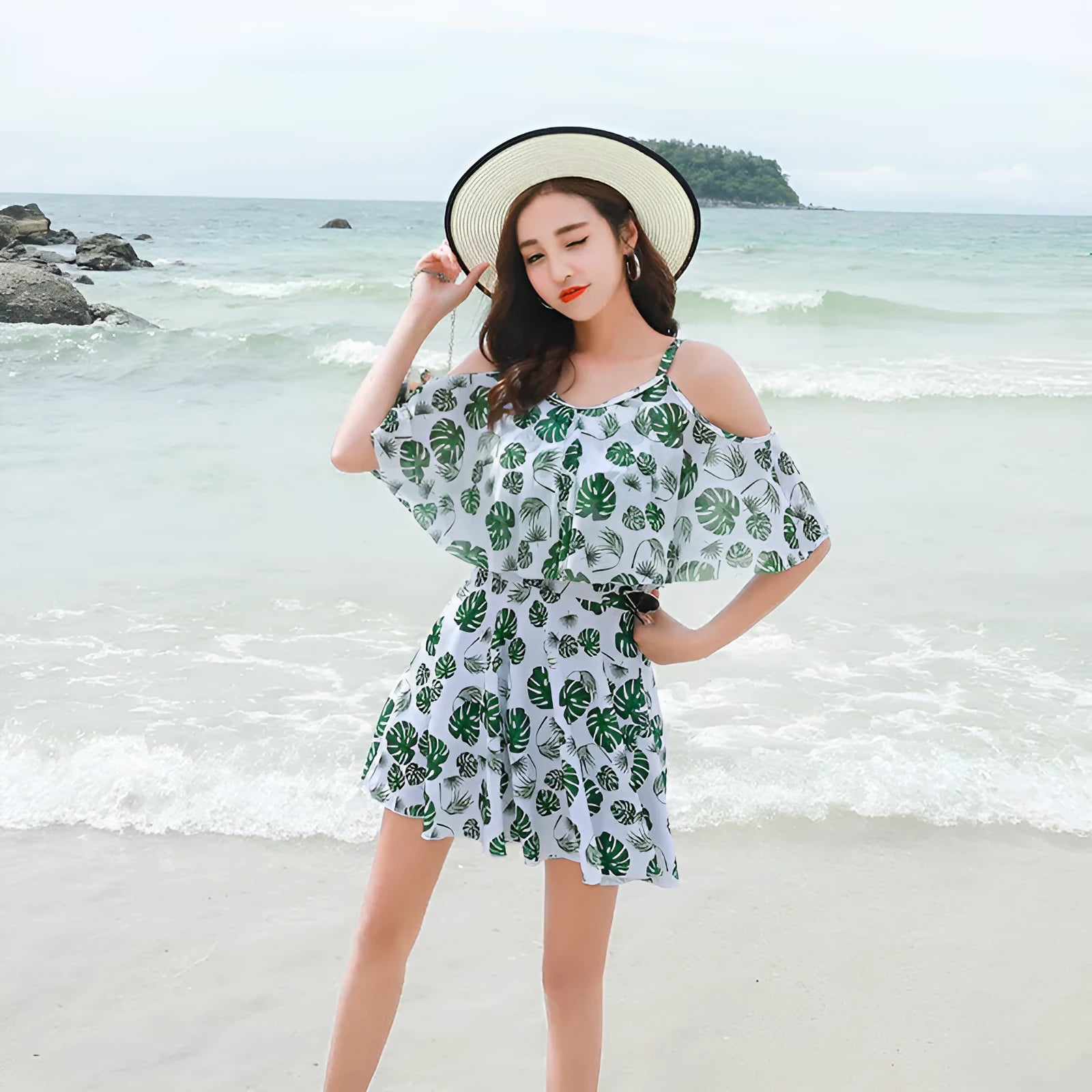 Women's green leaf style printed one-piece swimsuit laid flat.