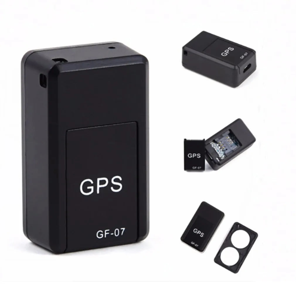 Small black plastic magnetic GPS tracker device next to a USB charging cable.