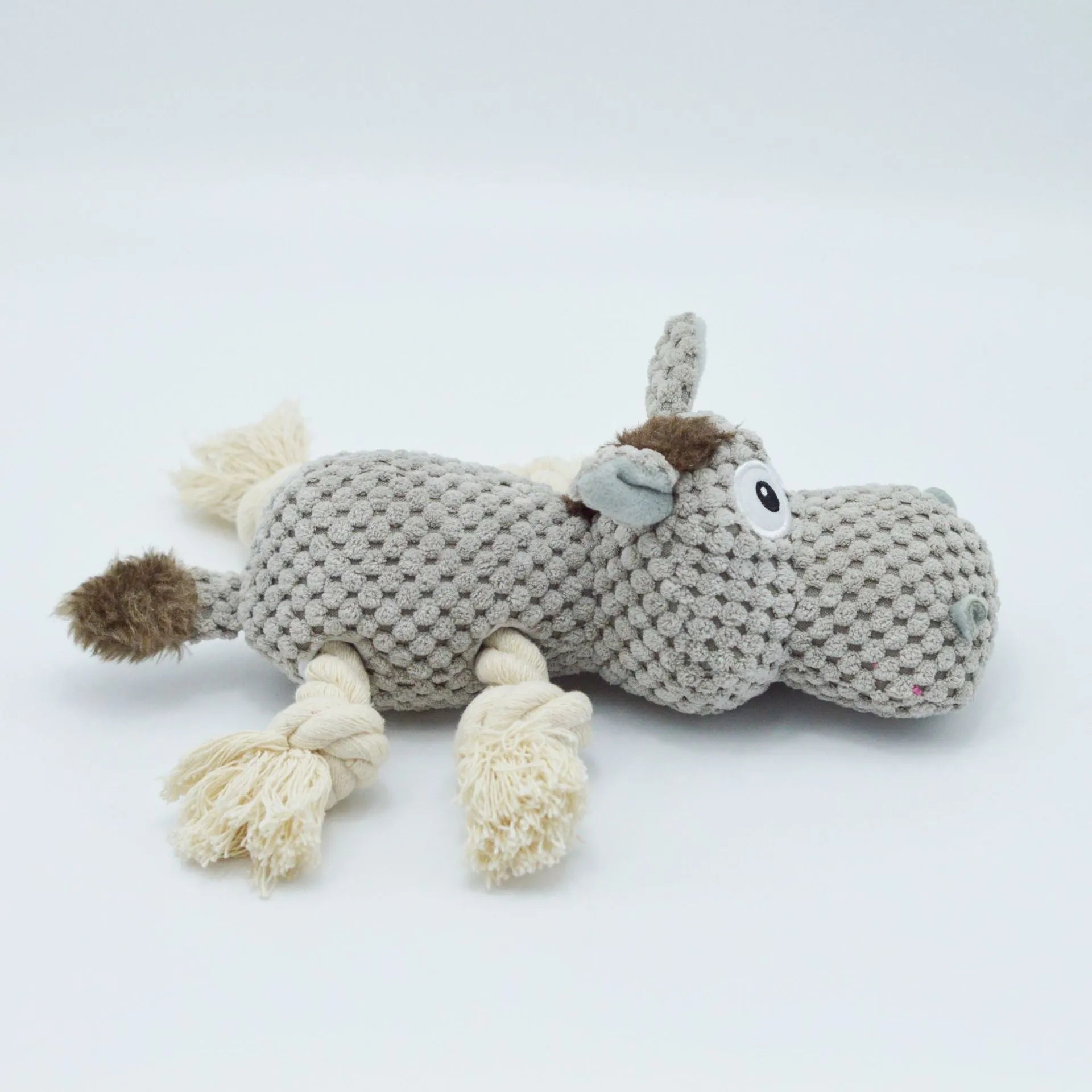 Grey plush donkey dog toy with creaking sound, showing size against a hand.