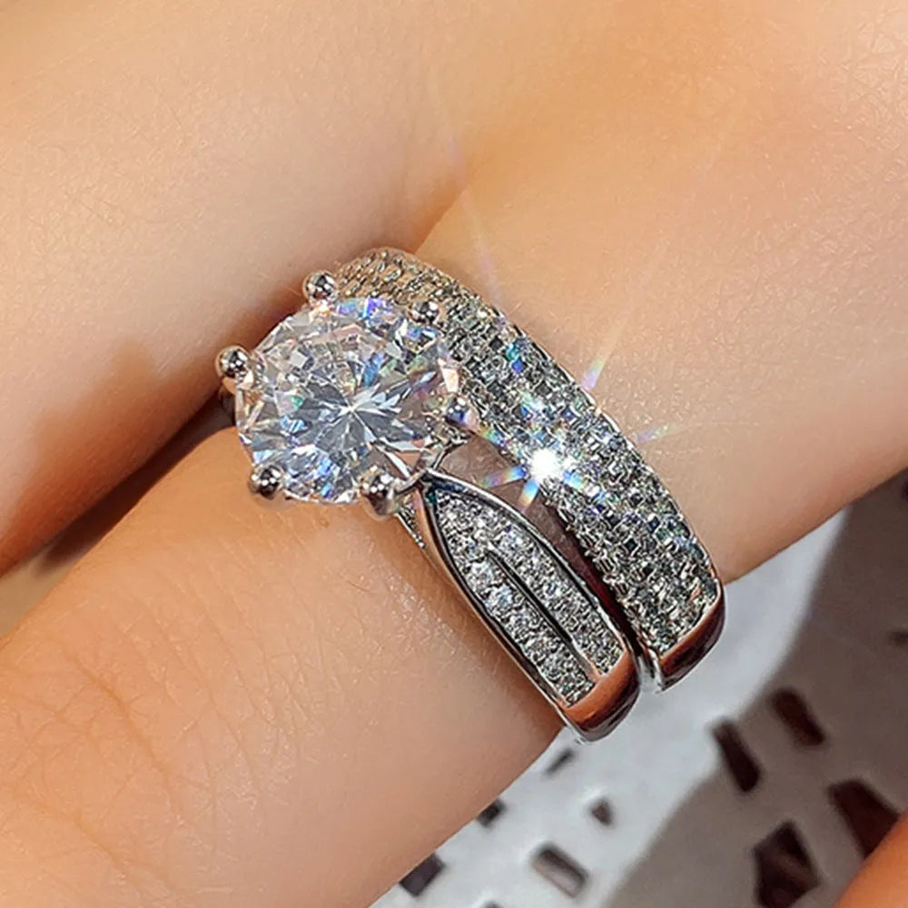 Geometric white gold colour alloy wedding ring bracelet with round detail on a finger.
