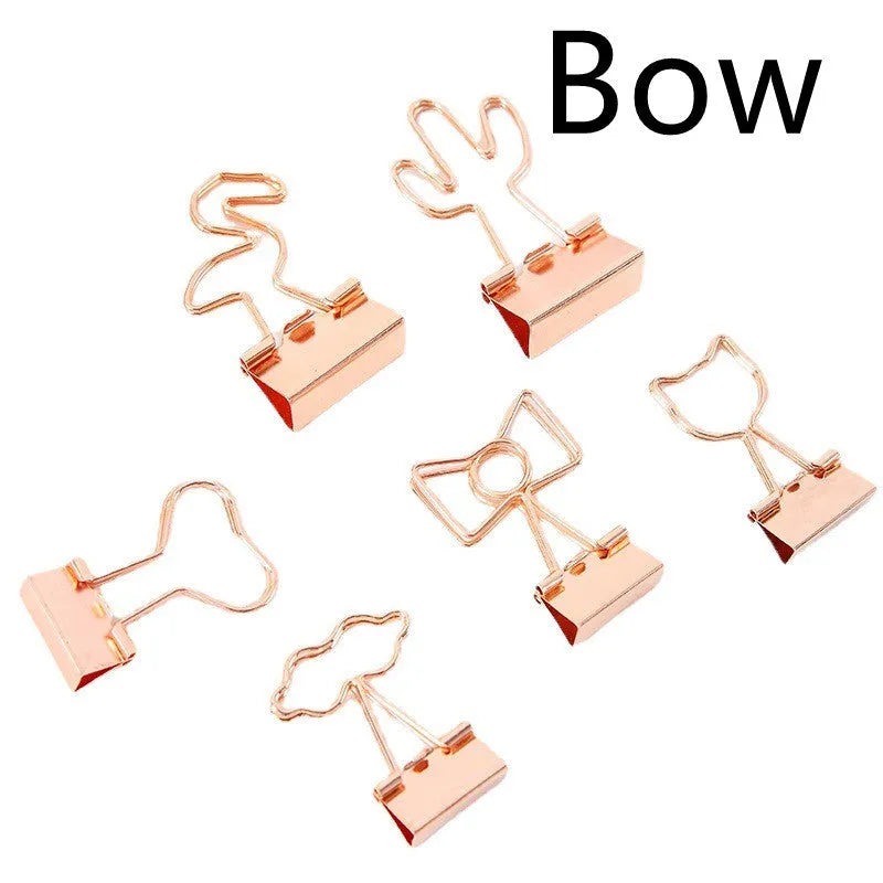 Small gold-plated metal office clip with a long tail, shown in a choice of flamingo, love, clouds, cat, and cactus shapes.