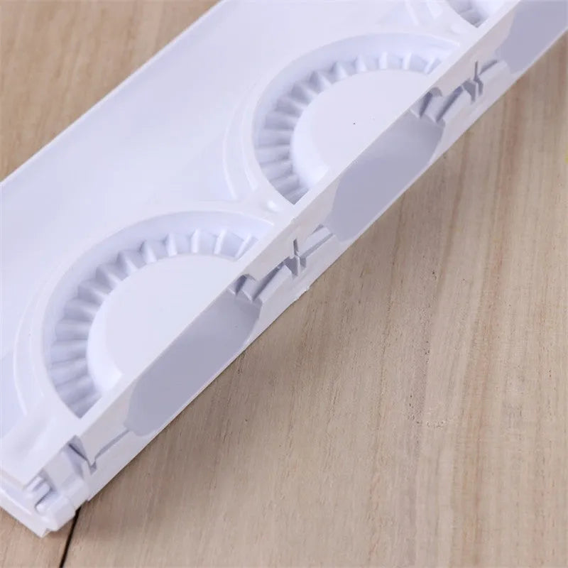 Pure white ABS plastic dumpling mould on a countertop, showing the mould shape for pressing dumplings