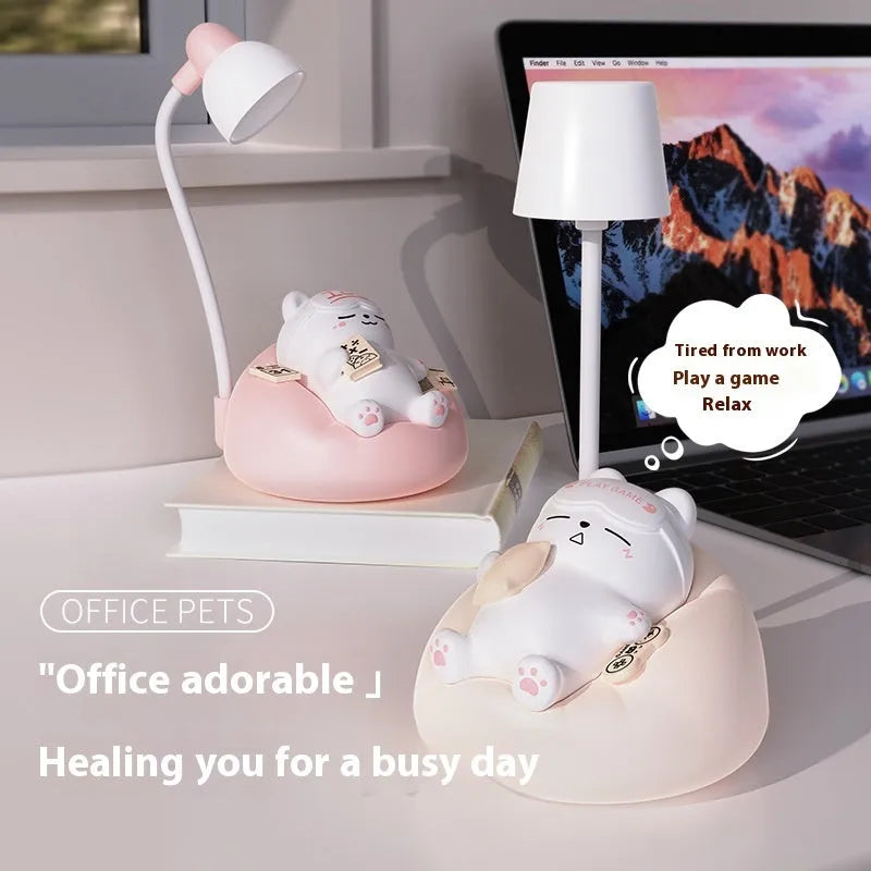 Sleeping cat shaped small night lamp in pink with USB charging cable on bedside table
