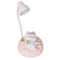 Sleeping cat shaped small night lamp in pink with USB charging cable on bedside table