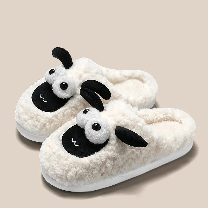 Brown suede slip-on slippers with a sewn PVC sole on a wooden floor.