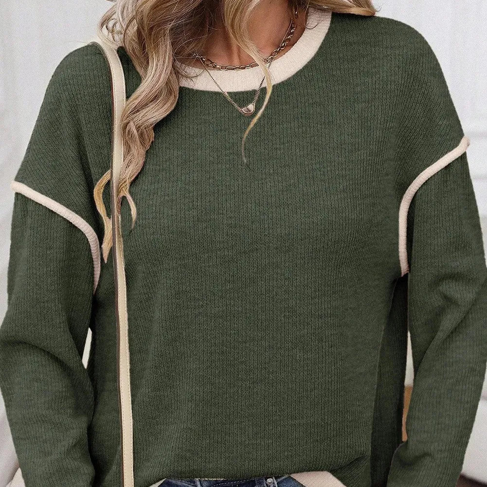 Women's beige knit top with green four leaf clover contrast trim on sleeves and neckline.