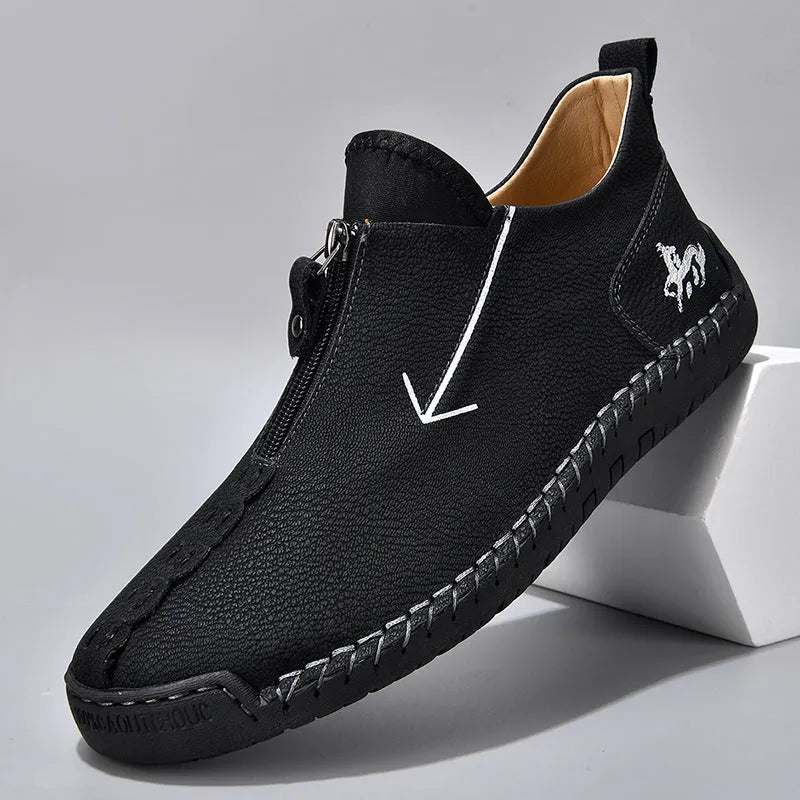 Men's black leather martin boots with a front zip, round toe, and hand-stitched seams on a rubber sole.