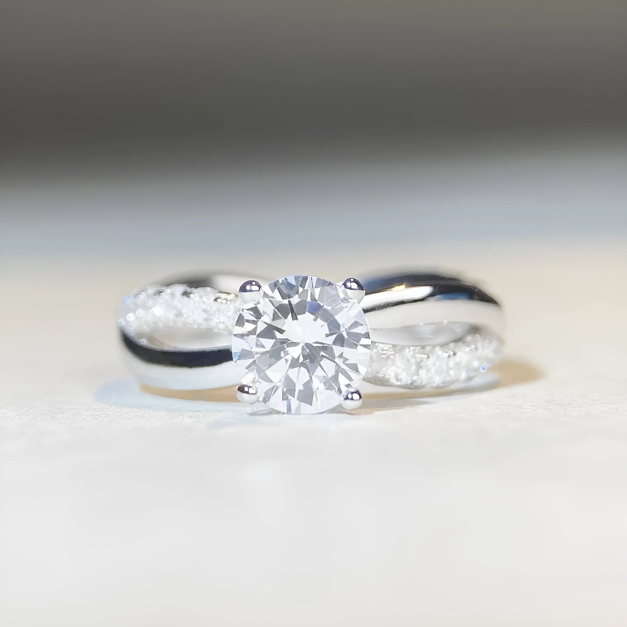 Silver geometric cross ring with a 1-karat moissanite stone on a twisted band.