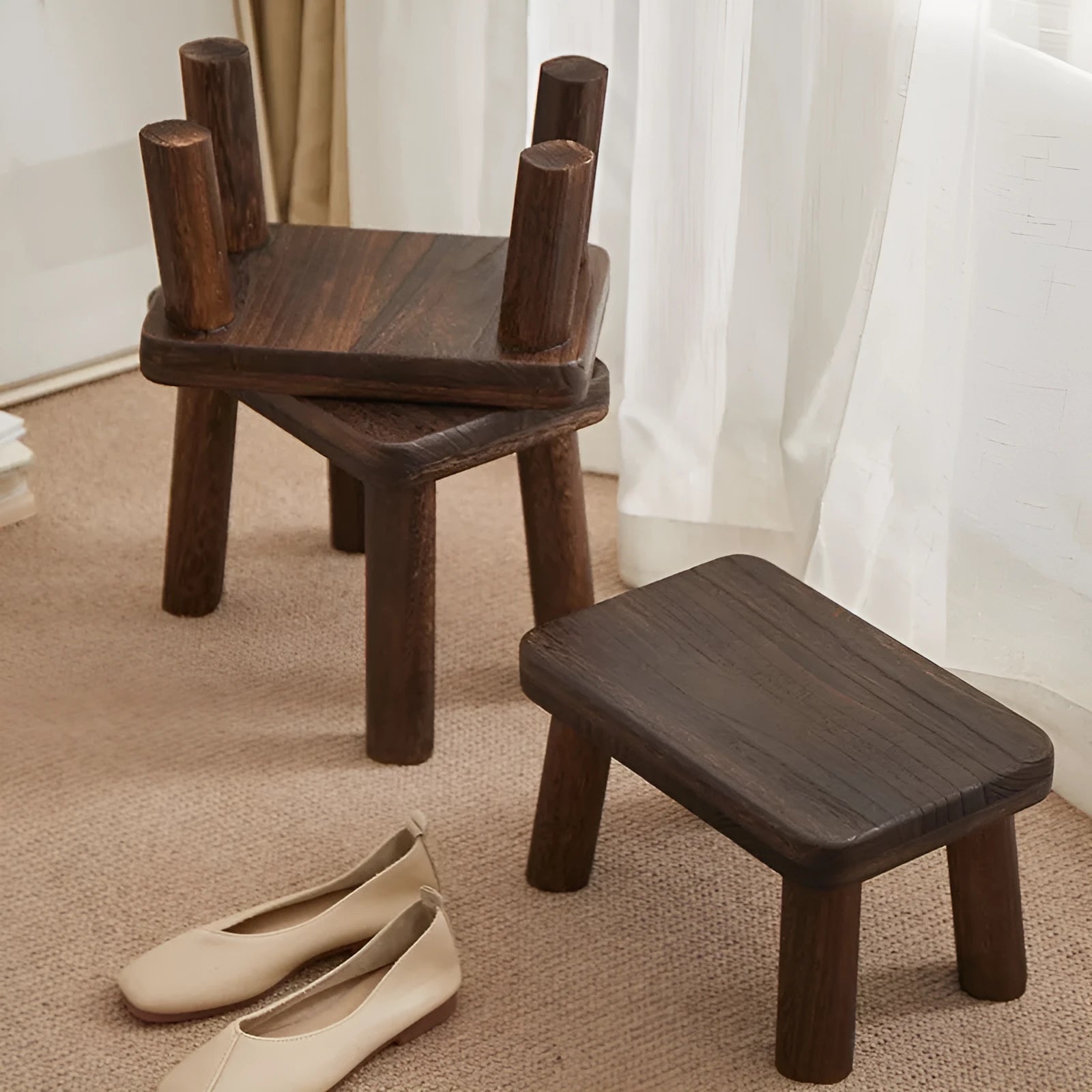 Solid wood distressed finish changing stool with bracket structure legs in a living room setting.