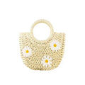Light brown straw weave crossbody bag with daisy accents and adjustable strap