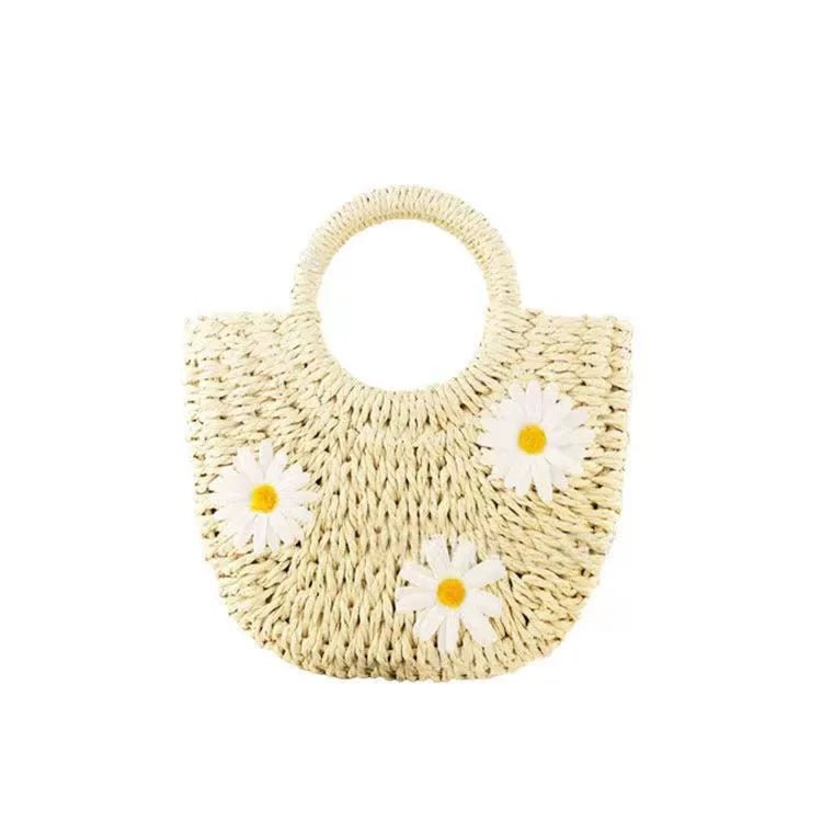 Light brown straw weave crossbody bag with daisy accents and adjustable strap