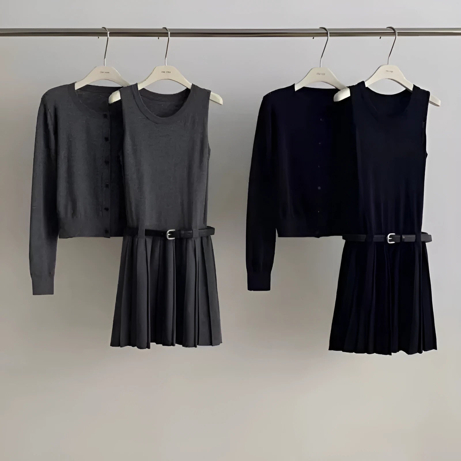 Grey knitted women's two-piece set with a pleated vest skirt and long-sleeved cardigan.