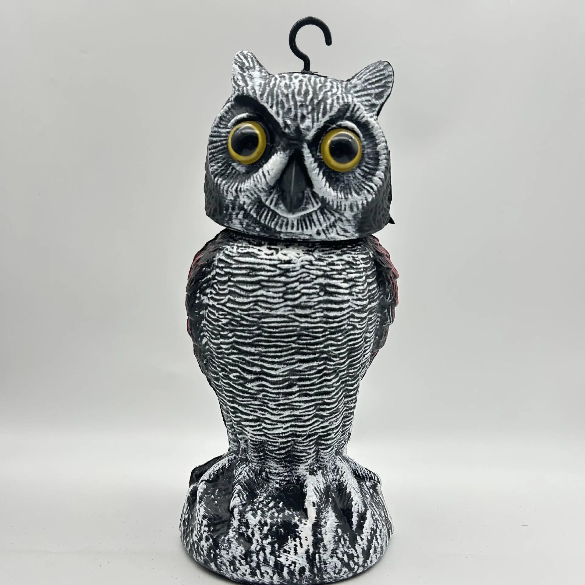 Artificial owl bird deterrent ornament with shaking head design in outdoor garden setting