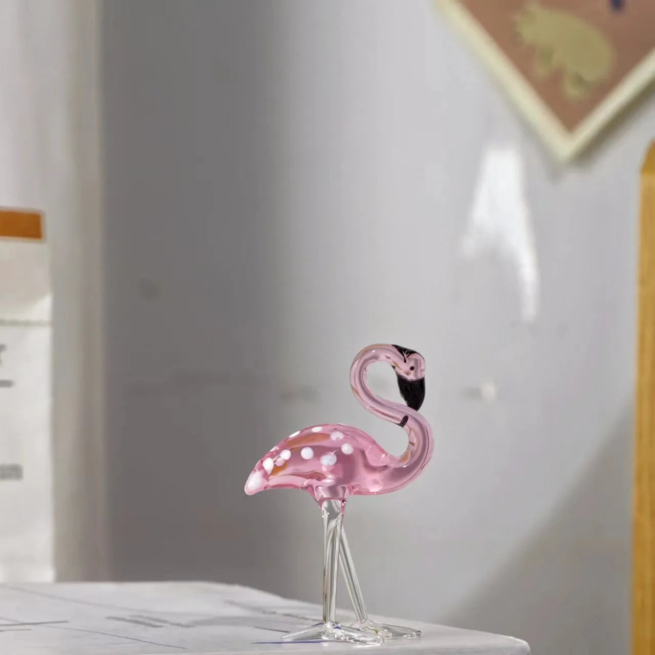 Pink and white crystal flamingo decorative ornament on a table, showing modern simple style.