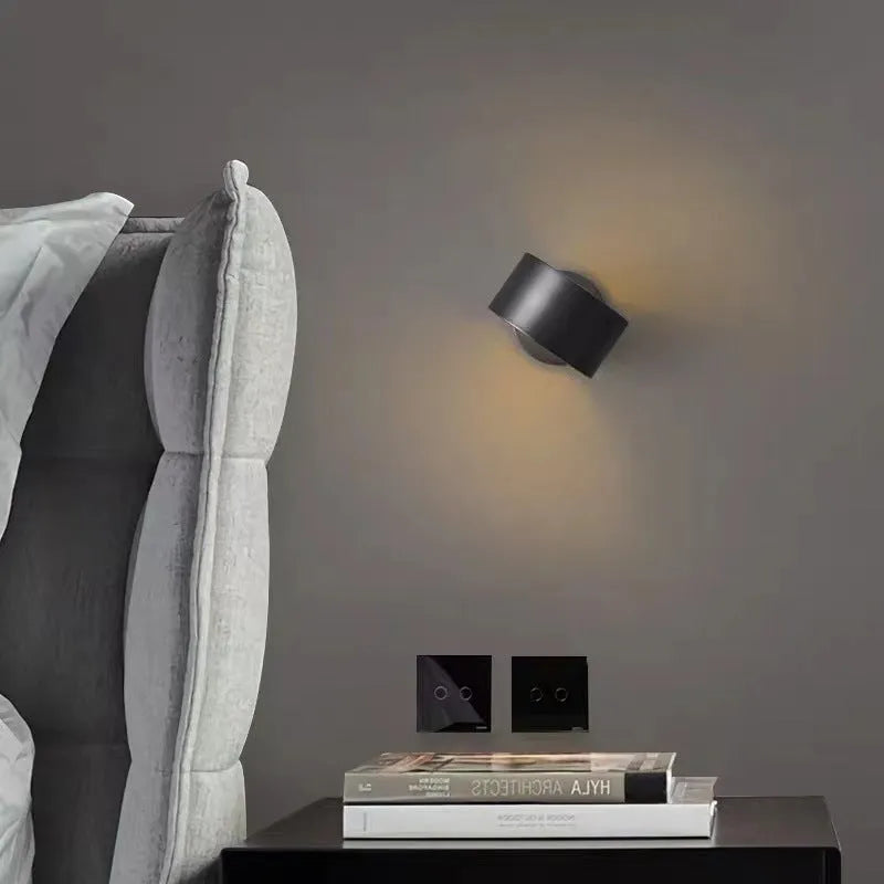 Modern minimalist copper wall lamp in gold finish mounted on a wall.