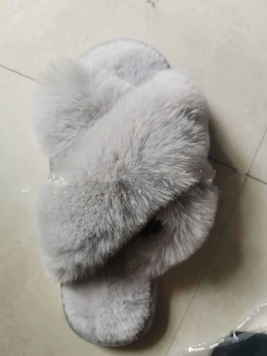 Women's beige faux fur cross-top slippers with suede upper and TPR sole on a wooden floor