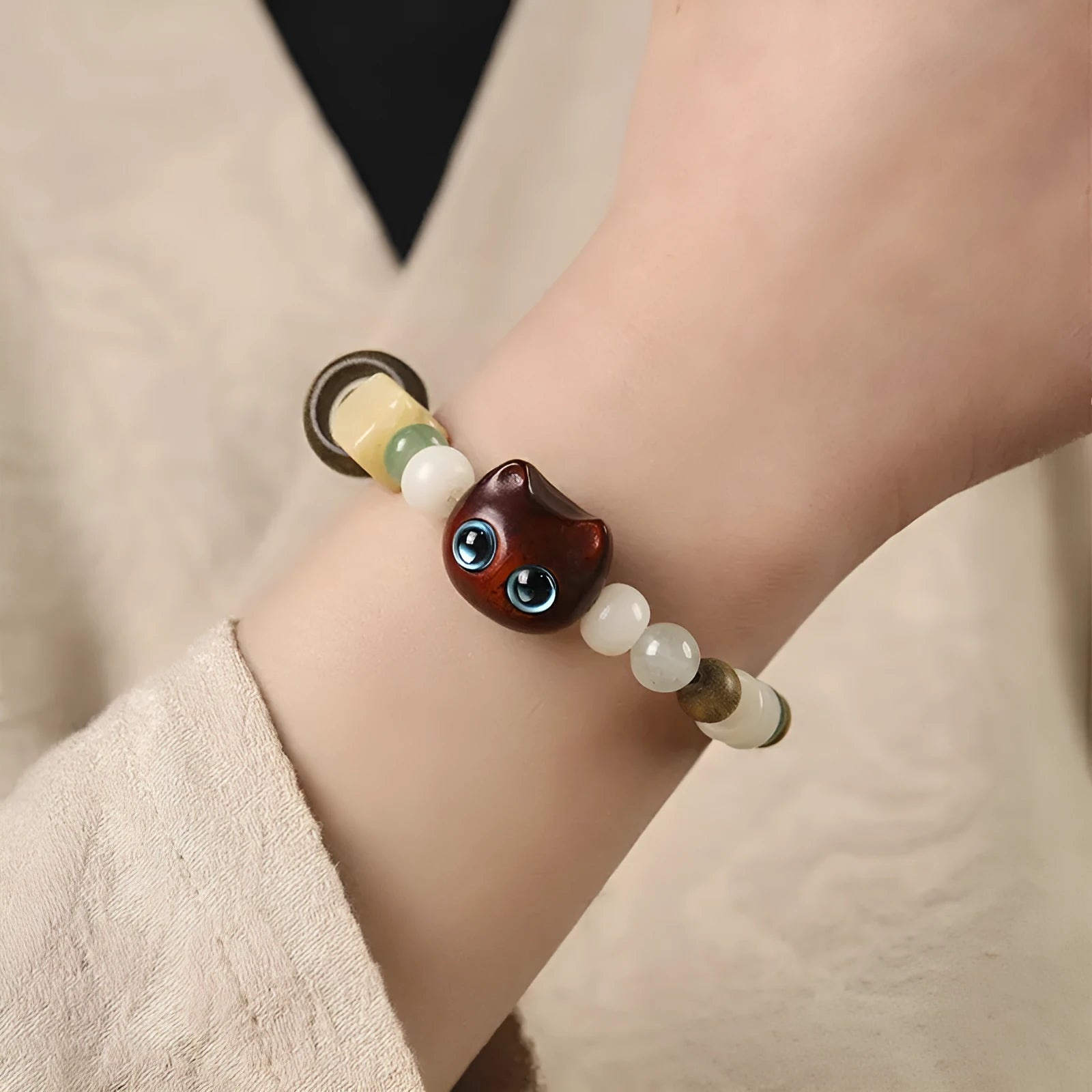 Hand-woven multi-treasure bracelet with Bodhi seeds, jade, and wood beads featuring a cat's paw charm.