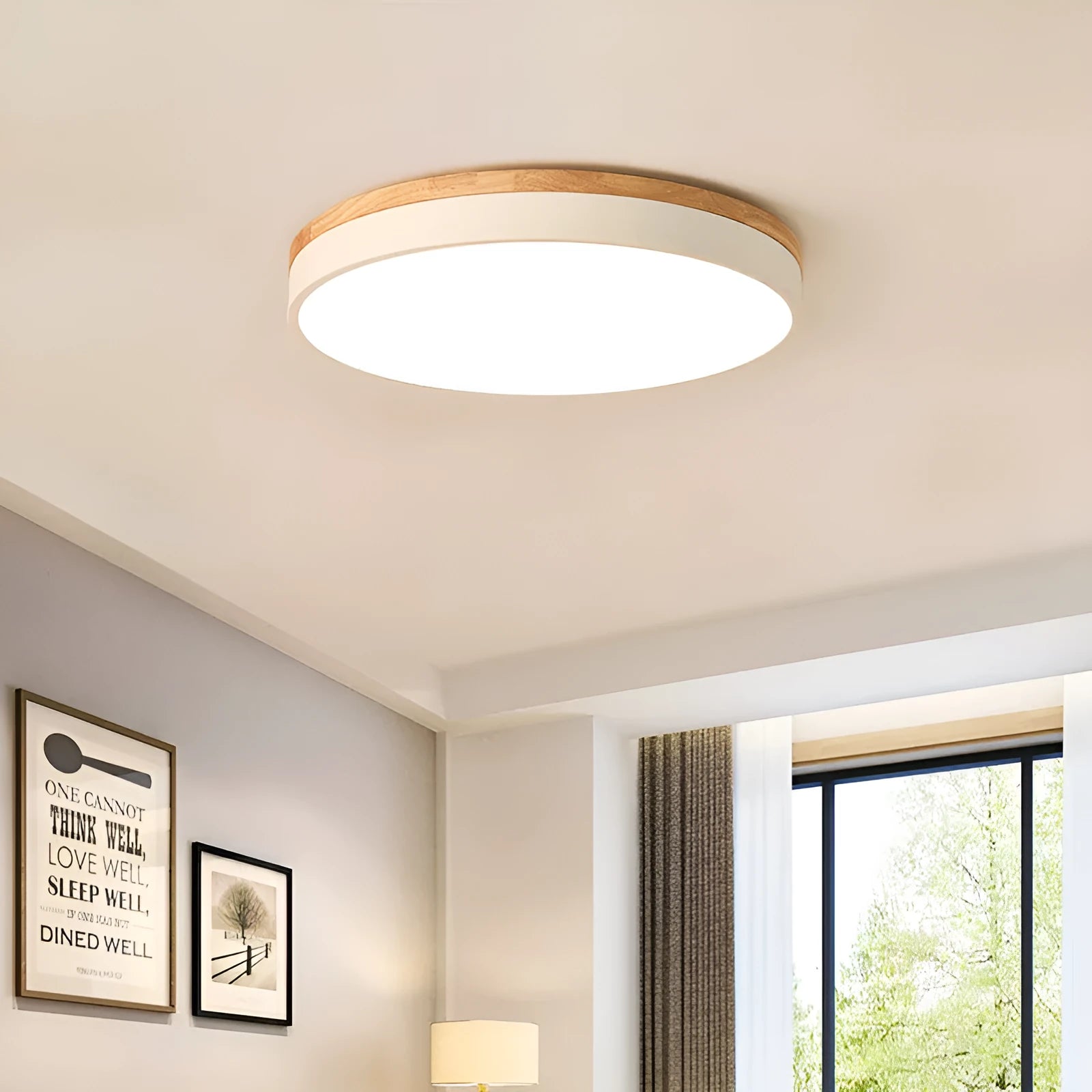 Round Scandinavian style wood and iron LED ceiling lamp with a white acrylic shade on a white ceiling.