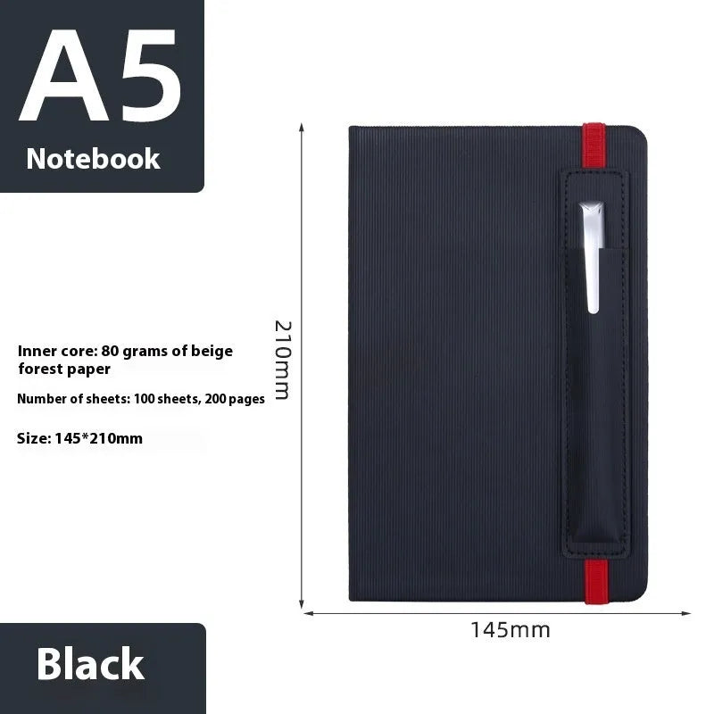 A5 faux leather notebook with pen insert and strap, open on a desk showing lined pages