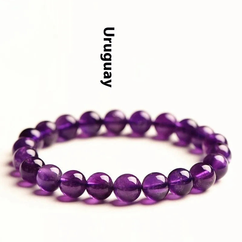 Natural amethyst Uruguay bracelet with scattered polished beads on a white background.