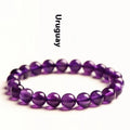Natural amethyst Uruguay bracelet with scattered polished beads on a white background.
