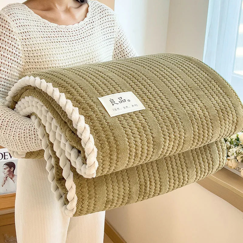 Solid colour jacquard milk velvet blanket in green on a bed with Nordic style decor