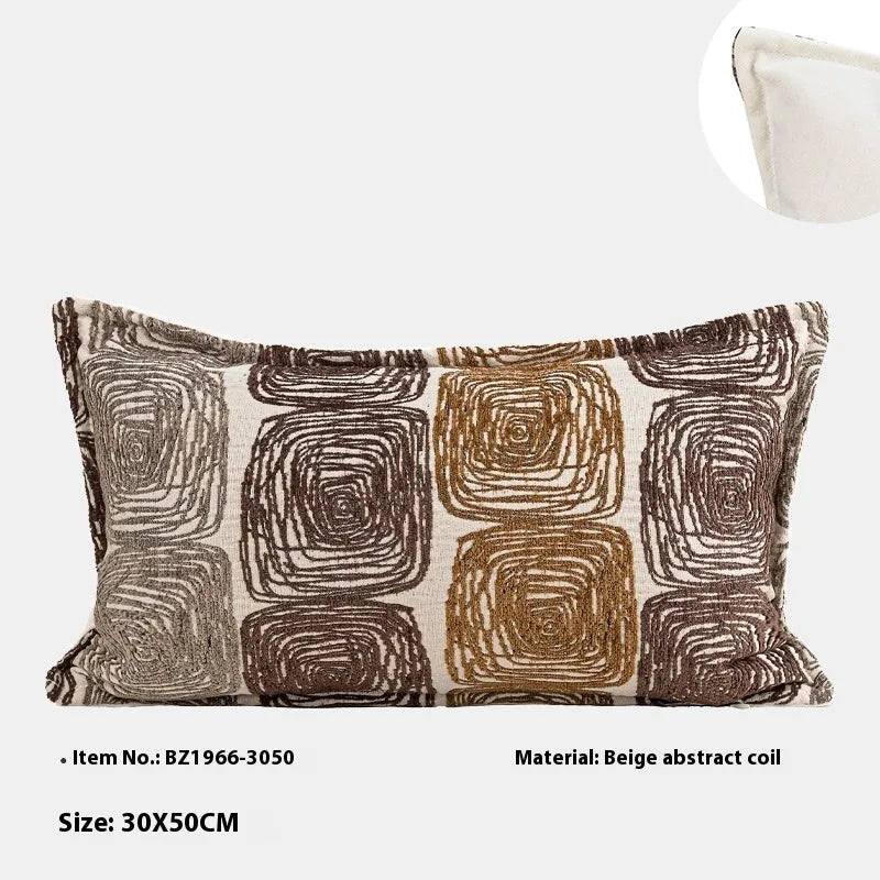 Square cream and coffee abstract coil pattern cushion cover on a grey sofa