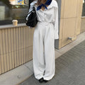 White striped wide-leg casual trousers with a zipper fastening on a neutral background.