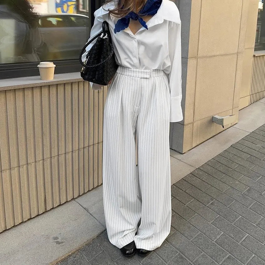 White striped wide-leg casual trousers with a zipper fastening on a neutral background.
