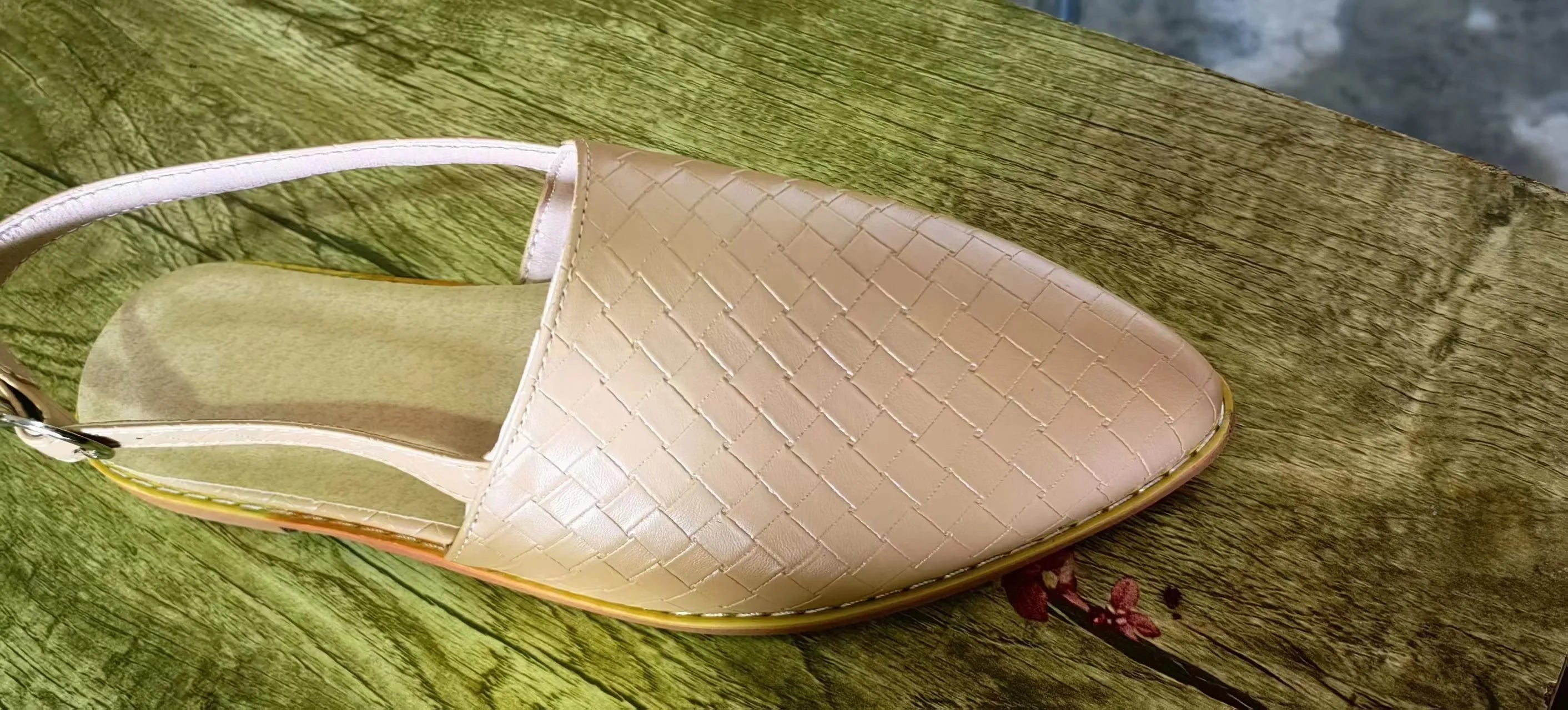 Women's black flat sandals with a buckle fastening and pointed toe on a rubber sole.