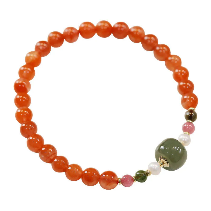 Women's bracelet made of round red South agate beads from Sichuan on a black elastic cord.