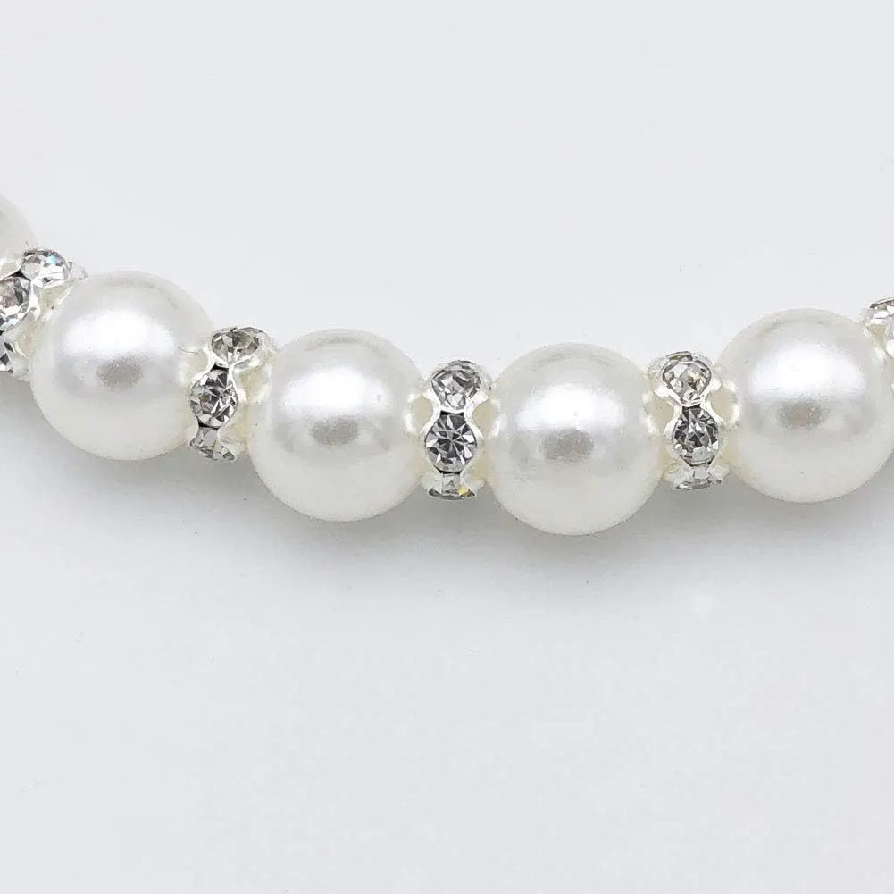Small dog wearing adjustable diamond pearl necklace with rhinestones and ribbon bow in blue colour