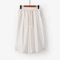 Wide leg cotton leisure shorts in apricot colour with embroidery detail, shown on a hanger.