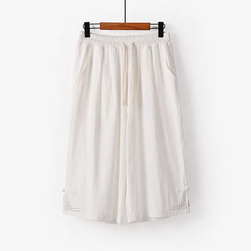 Wide leg cotton leisure shorts in apricot colour with embroidery detail, shown on a hanger.