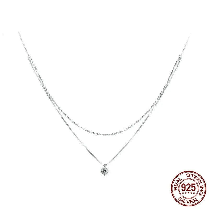 Close-up of a double-layer sterling silver necklace with a pearl-style chain, showing its layered design and silver finish.
