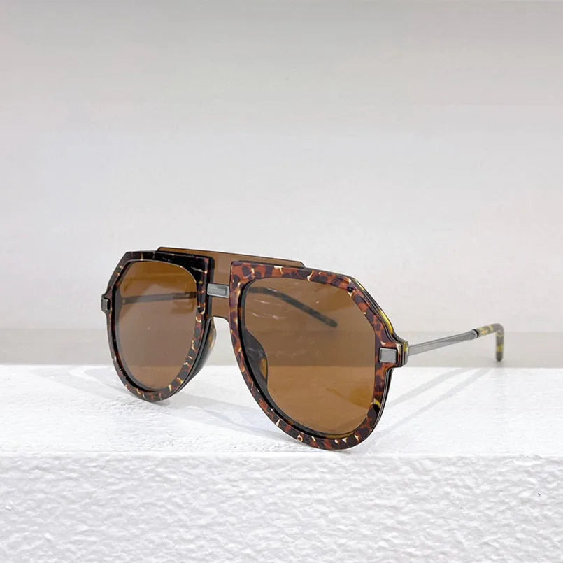 Black leopard print retro sunglasses with large elliptical frame on display.