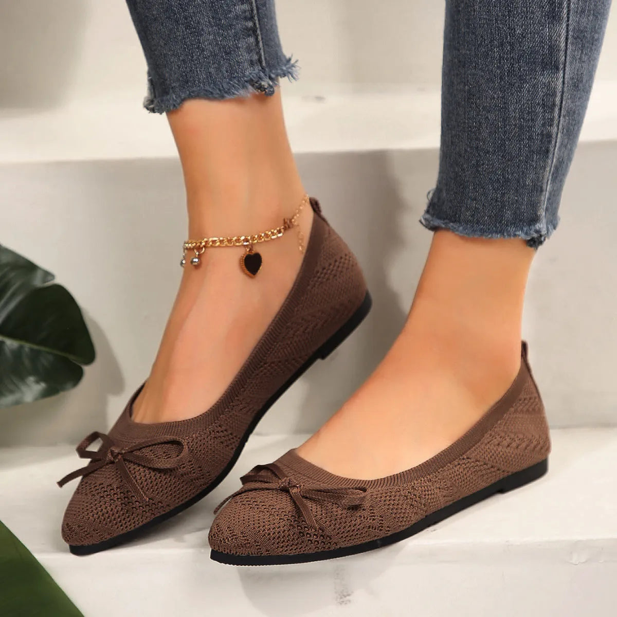 Women's blue knitted loafers with a bow and pointed toe on a flat rubber sole.