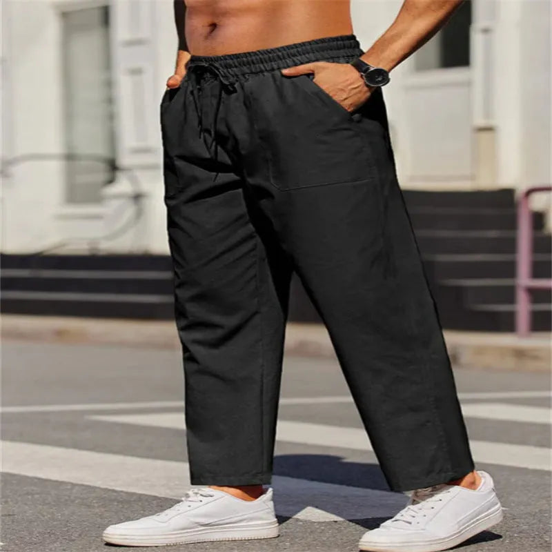 Men's straight-leg linen trousers in a solid colour, showing the elasticated mid waist and long leg.