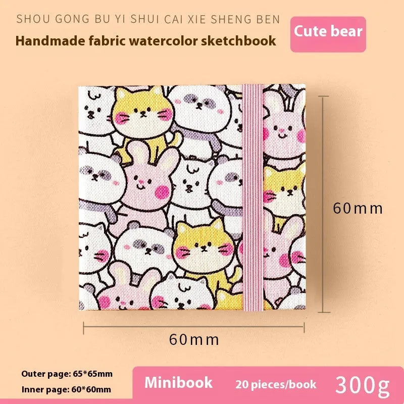 Feiluniao handmade fabric watercolour notebook with illustrated cover, open to show blank paper pages.