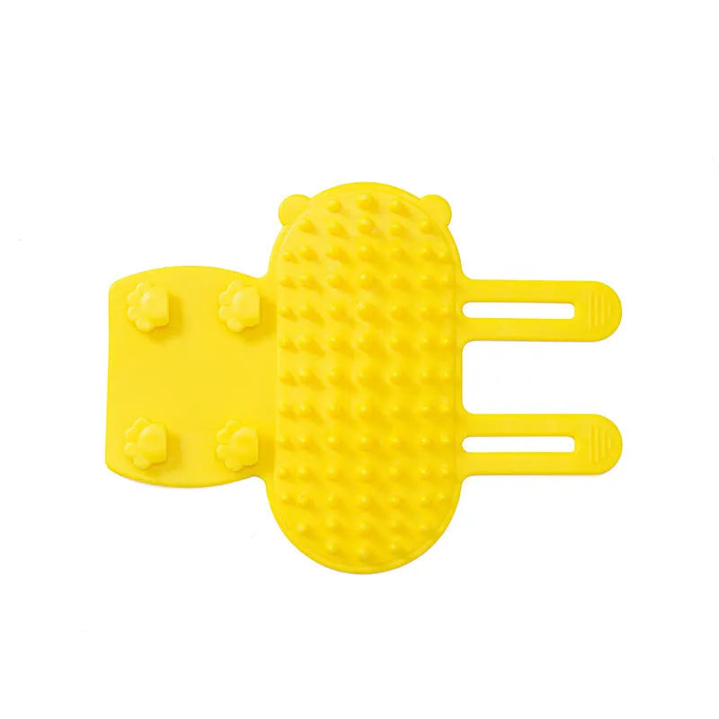 Black silicone cat grooming brush with comb teeth and an adjustable mounting strap.
