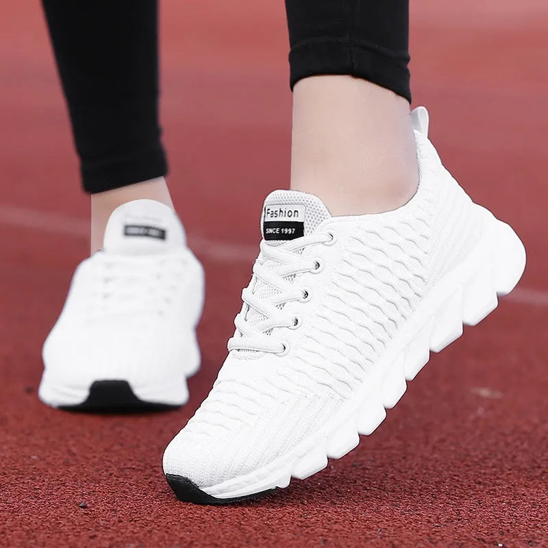 Women's running shoes in black, pink, or white with a fly-weave upper and durable outsole.