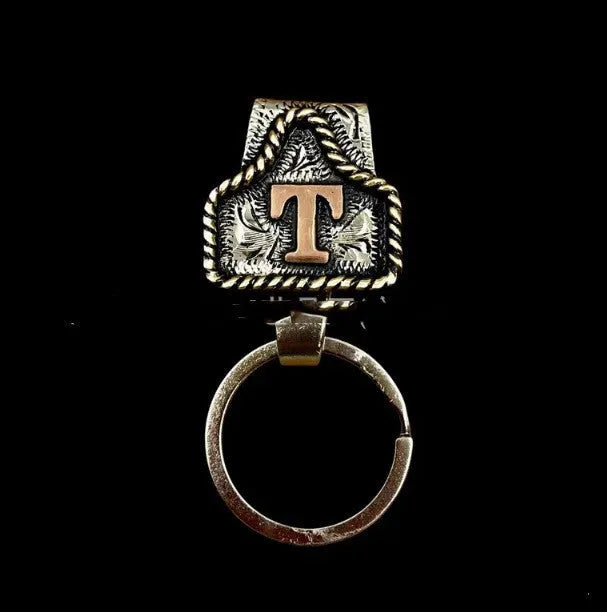 Handmade metal cow tag style key holder shown in one of its 26 colour options, attached to a keyring.