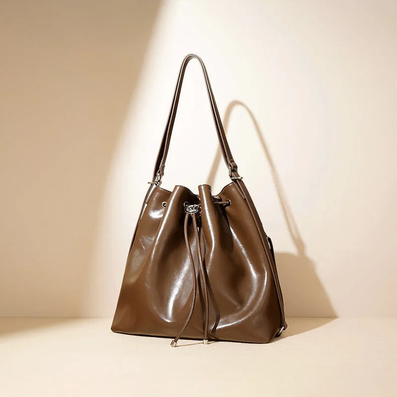 Genuine leather one shoulder bucket bag in brown showing retro style and interior pockets.