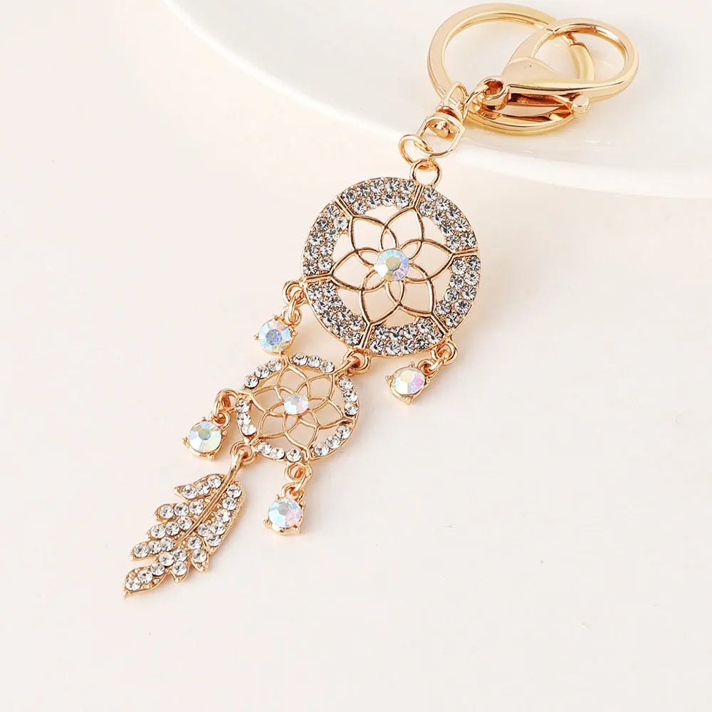 Creative diamond studded flower shaped car keychain dream catcher in pink alloy light luxury style on white background