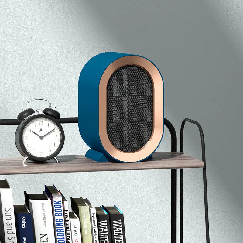Desktop electric fan heater with black casing and UK plug, showing control knob and air vents