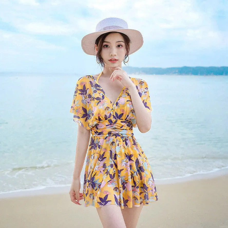 Yellow floral print women's one-piece swimsuit on hanger showing front design